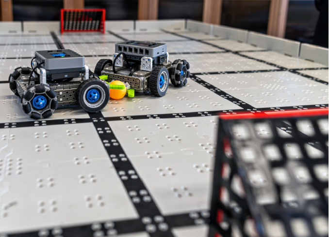Two wheeled robots competing on a robotics field mat
